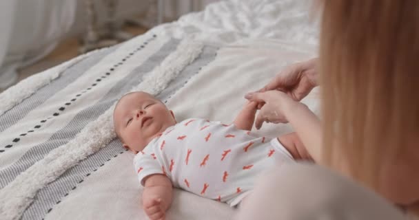 엄마는 갓 태어난 아기에게 크림 냄새를 맡긴다. 새끼의 피부 관리. — 비디오