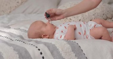 The mother drips vitamins to the child to strengthen the immune system.