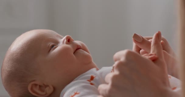 Nyfött barn på nära håll. Mamma håller barnet i handtagen. — Stockvideo