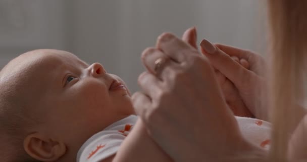 Nyfött barn på nära håll. Barnet tittar på sin mor och viftar med munnen. — Stockvideo