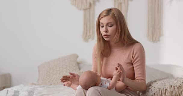 Mamma lugnar ett gråtande barn. Mamma berättar barndikter för barnet. — Stockvideo