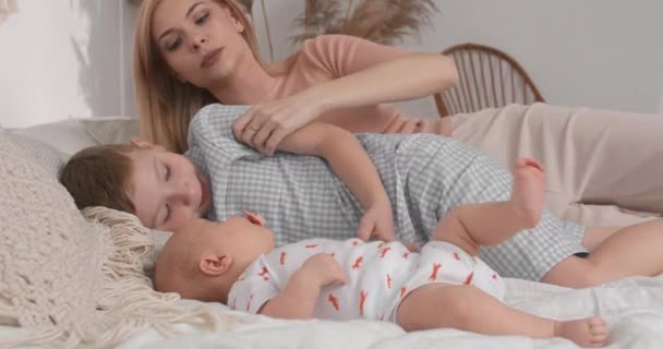 Mamá pone a los niños a dormir a la hora del almuerzo. Mamá se va a descansar con los niños en el almuerzo.. — Vídeos de Stock