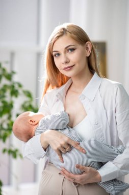 Anne bebeği emzirdi ve onu kollarına aldı. Anne sevgisi en güçlüsüdür. Yatay fotoğraf.