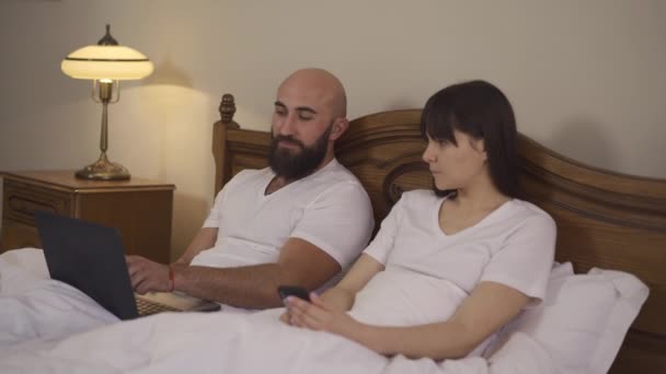 Pareja Casada Cama Discutiendo Viaje Conjunto Para Próxima Semana Vídeo — Vídeo de stock