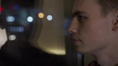 Genç yakışıklı adam pencerenin önünde üzgün bir ifadeyle durup hayatı düşünüyor..