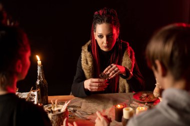 People who came to the witch to know the future. Visit to the seer. Mystical interior. Horizontal photo.