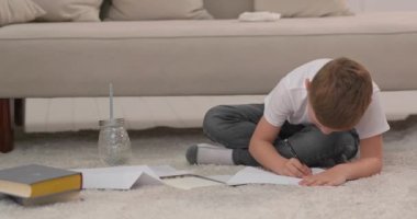 Çocuk ailesini kağıda çizer. Çocuk evde çizim yapar ve yere oturur. Bir çocuğun çabalarıyla.