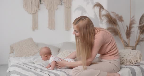 母親は子供の体調を改善するために毎朝赤ちゃんと一緒に練習します 水平ビデオ — ストック動画