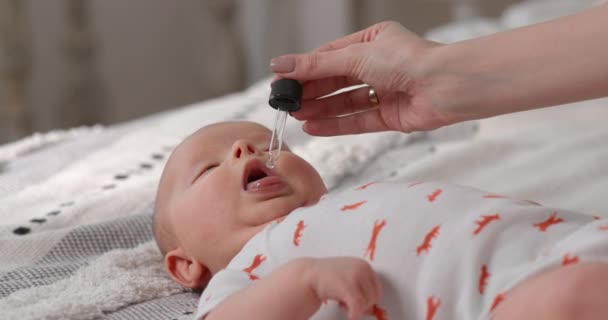母親は毎日 赤ちゃんの免疫システムを強化するために子供のビタミンを与えます 新生児の健康管理 — ストック動画