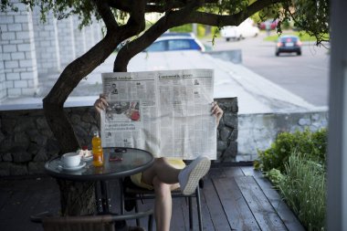 Sabahın köründe, rahat bir kafede, elinde gazete olan bir kahve. Retro fotoğraf