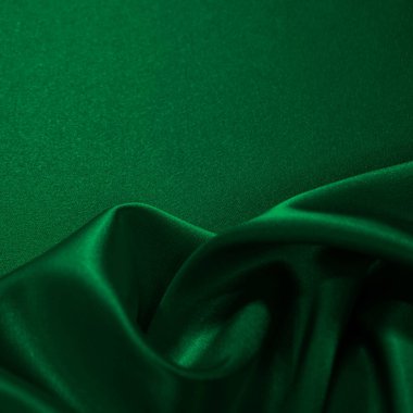     Koyu yeşil ipek kadife. Güzel yumuşak dalgalı kıvrımlar parlak kumaş üzerinde. Tasarım için kopyalama alanı olan zarif bir arkaplan. Noel, tatil, şenlik.                           