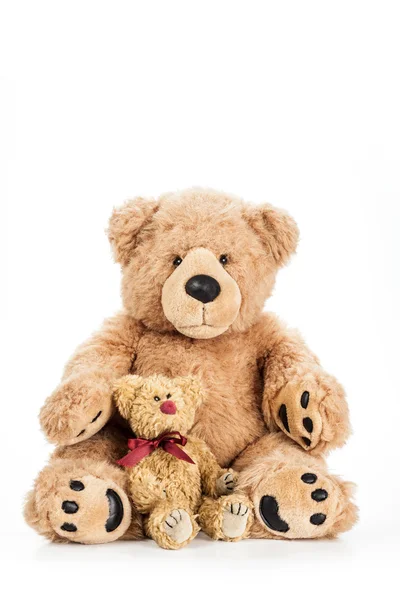Niedlicher Teddybär sitzt mit einem kleinen Kind Stockbild