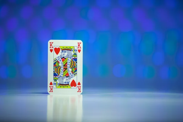 Red heart King playing card with blue blurry circle background