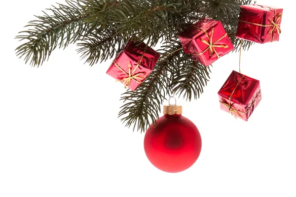 Bola roja del árbol de Navidad y pequeños paquetes rojos en una ramita de abeto — Foto de Stock
