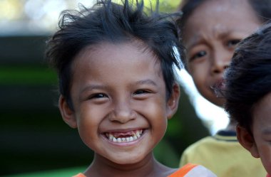 Kenjeran plaj çocukları 13 Haziran 2003 'te Kenjeran Sahili, Surabaya, Doğu Java, Endonezya' da oynarken gülümsüyor