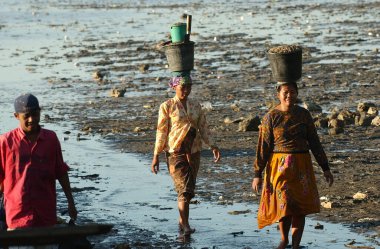 13 Haziran 2003 'te Surabaya City, Doğu Java, Endonezya' da kurak mevsimde çekilen deniz solucanları avlandıktan sonra Kenjeran Sahili yakınlarında yaşayan insanlar sahili terk ediyor.