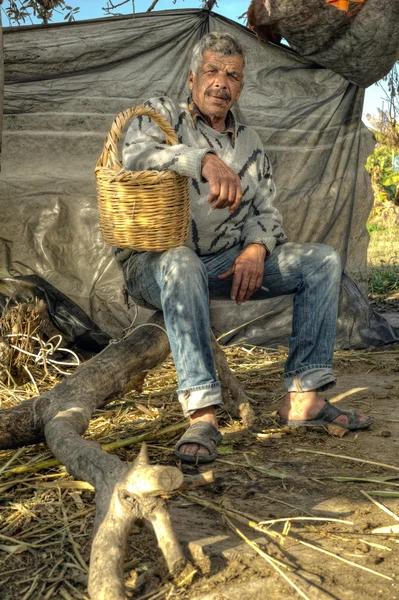 Senior farmer holding a basket and resting — Stock Photo, Image