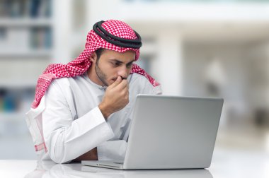 dizüstü bilgisayarda çalışan Arap iş adamı