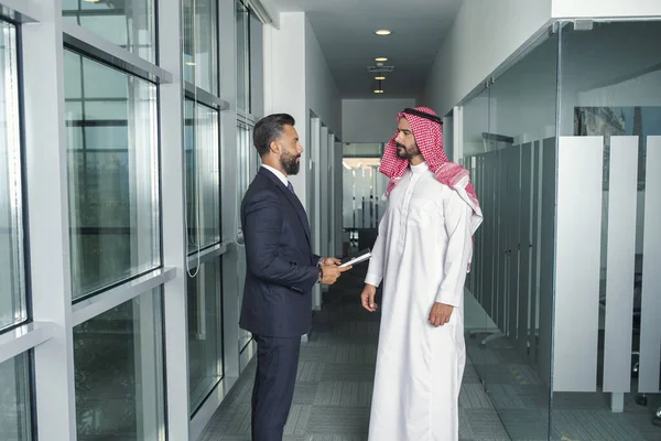 現代のオフィスで仕事を議論する外国人ビジネスマンとアラビア語のビジネスマン — ストック写真