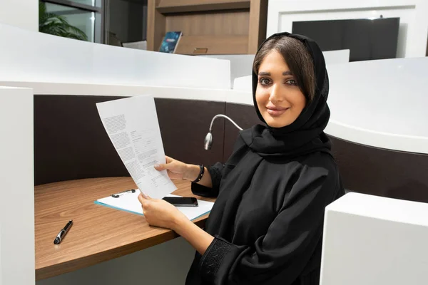 オフィスで働いている陽気なアラビア人実業家の肖像画とカメラを見て ストック画像