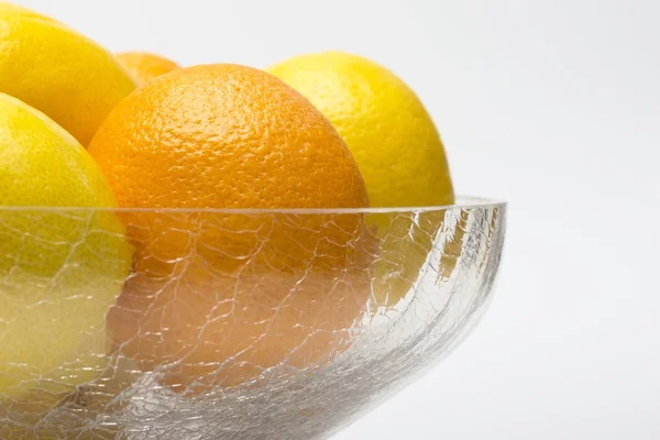 Oranges and lemons in glass bowl — Stock Photo, Image