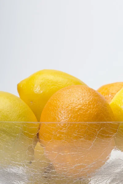 Oranges and lemons in glass bowl — Stock Photo, Image