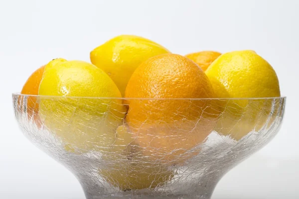 Oranges and lemons in glass bowl — Stock Photo, Image