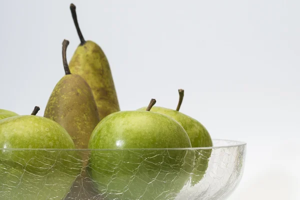 Manzanas y peras en tazón de vidrio —  Fotos de Stock