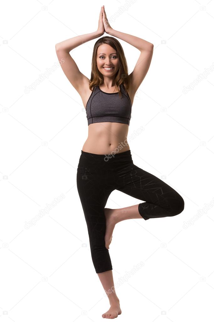 A woman standing yoga on one leg.