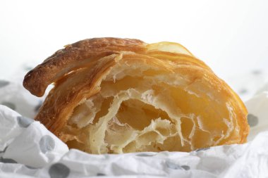 Beyaz arka planlı noktalı peçeteye kesilmiş kruvasan.