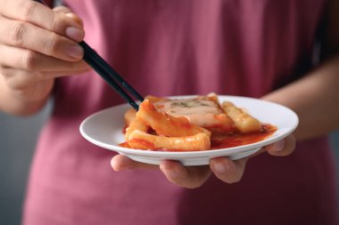 Kore yemeği, Tteokbokki (dilimlenmiş pirinç keki) veya yemek çubukları tarafından yenen baharatlı soslu peynirli tokpokki ve sosis