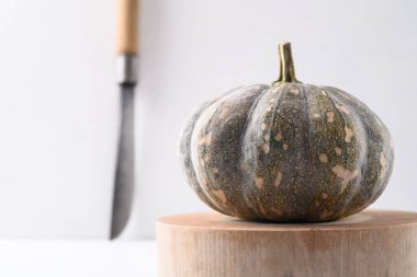 Tahtayı bıçakla kesen organik Tayland balkabağı beyaz arka planda yemek pişirmeye hazır ol.