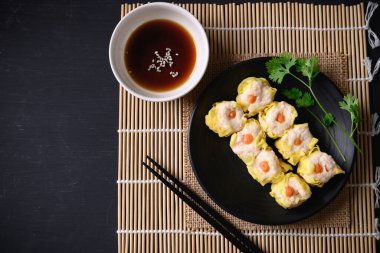 Karides shumai, içi doğranmış karides ve geleneksel Çin usulü buğulanmış hamur köftesi ile dolu açık soslu hamur tatlısı.