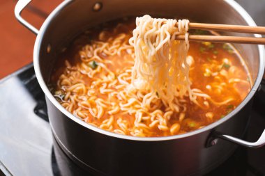 Asya baharatlı hazır şehriye çorbası yemek çubuklarıyla sıcak tencerede pişiyor.