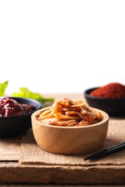 Gochujang (kırmızı biber ezmesi) ve ahşap arka planda kırmızı biber tozu ile Kore kimçili lahana.
