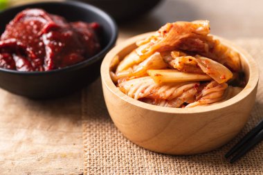 Ahşap arka planda Kore kimçili lahana ve gochujang (kırmızı biber ezmesi).
