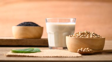 Tahta arka planda siyah susamlı soya sütü, sağlıklı içecek.
