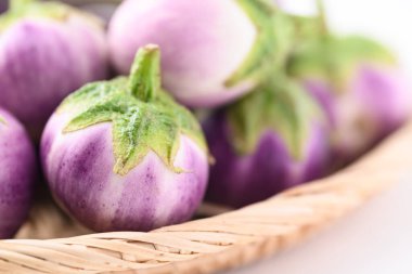 Taze organik Tayland mor patlıcanlarını sepete koy.