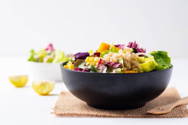 Beyaz arka planda kinoa tohumlu taze organik sebze salatası, sağlıklı vegan yemeği.