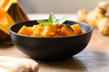 Tahta masada domuz etli baharatlı balkabağı çorbası.