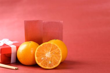 Turuncu meyve, kırmızı zarf ve kırmızı arka planda hediye kutusu, Çin Yeni Yıl konsepti