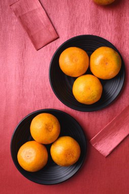 Kırmızı arka planda turuncu meyve ve kırmızı paket, Çin Yeni Yılı, Ay Yeni Yılı