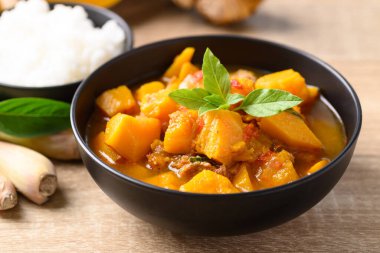 Tahta masada domuz etli baharatlı balkabağı çorbası.