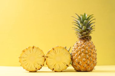 Sarı arka planda taze ananas meyvesi, tropikal meyve.