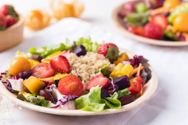 Beyaz arka planda taze karışık meyve ve sebze salatası, sağlıklı vejetaryen yemeği.