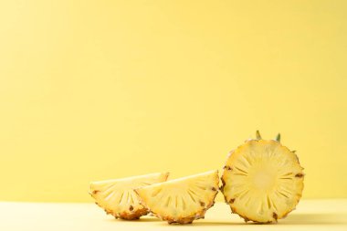 Yarısı ve sarı arka planda dilimlenmiş ananas meyvesi, tropikal meyve.