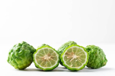 Organik Kafir kireç, Güneydoğu Asya mutfağında kullanılan turunçgil meyvesi ve beyaz zemin üzerinde gerekli yağ