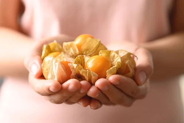 Cape gooseberry or golden berry (Physalis peruviana) holding by woman hand, Healthy tropical fruit