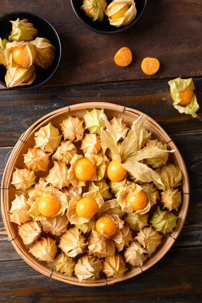 Cape gooseberry or golden berry (Physalis peruviana) on wooden background, Healthy tropical fruit, Table top view