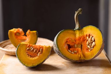 Asyalı balkabağı ahşap kesim tahtasında pişirme için hazırlanıyor, yerel marketten organik sebzeler.